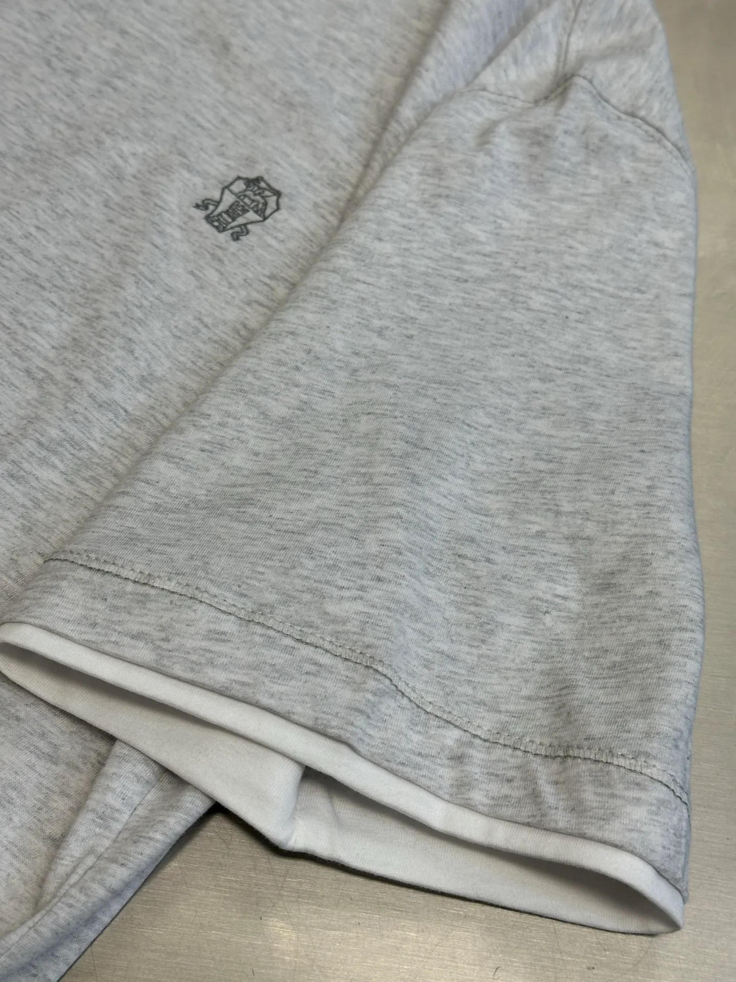 Bc Embroidered Badge Stacked Short Sleeves Made of custom-made densely woven plain organic cotton fabric, the round neck is decorated with sharp triangular language, visually extending the neck line, and the iconic Solomeo badge is embellished on the chest, making it highly recognizable. Contrasting color inlays create a layered effect, and the illusion aesthetic of two pieces gives rise to a sense of high-end and endless imagination between similarity and dissimilarity, and every move is inadvertently exquisite. With glue printing, glue liquid paint is used to print patterns on the fabric, and the fabric is baked to fix the printed pattern. size：s m l xl